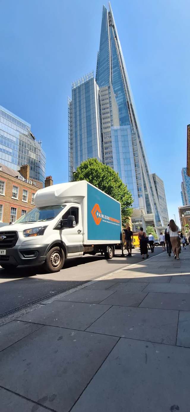 Painless Removals branded van on a London street beneath The Shard during a London-to-Bristol office relocation